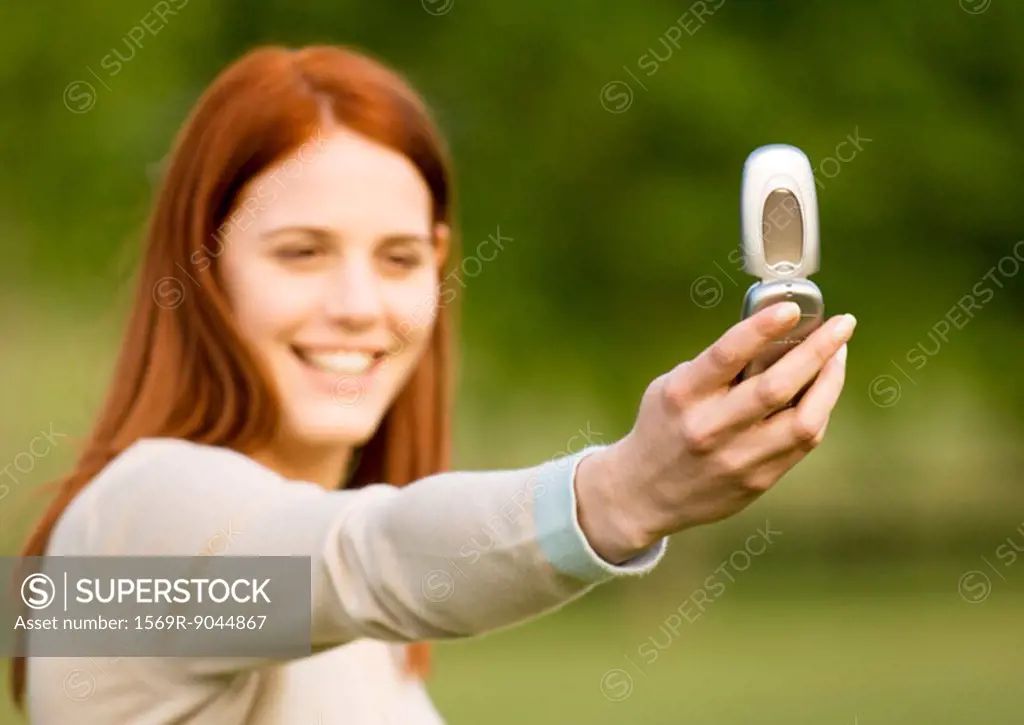 Young woman taking photo with cell phone