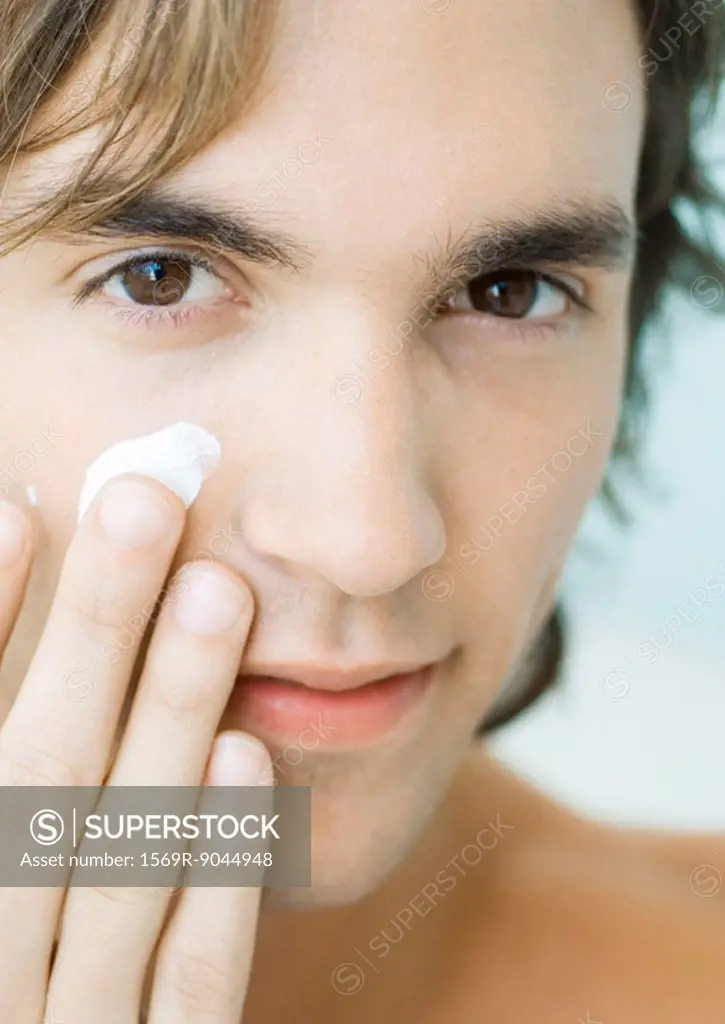 Man putting moisturizer on face