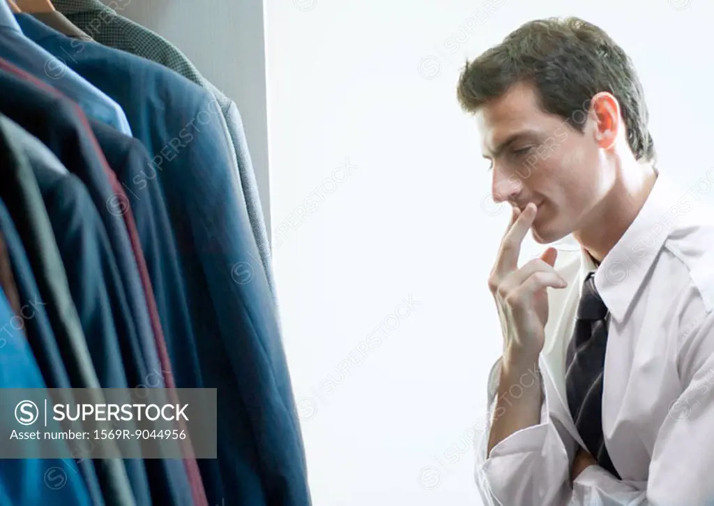 Man choosing jacket from closet