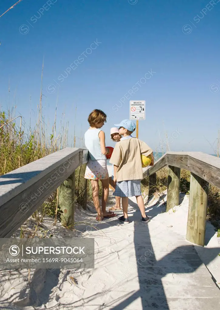 Children standing on beach walkway