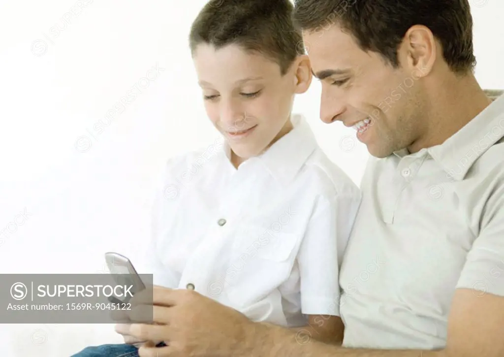Man and son looking at cell phone together