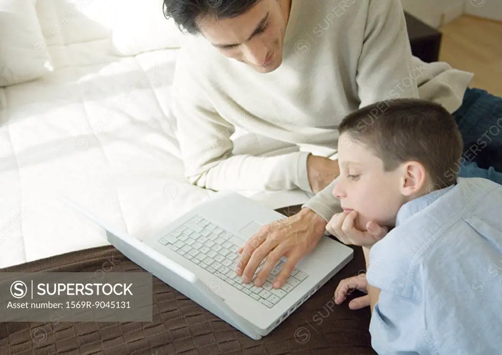 Man and son using laptop