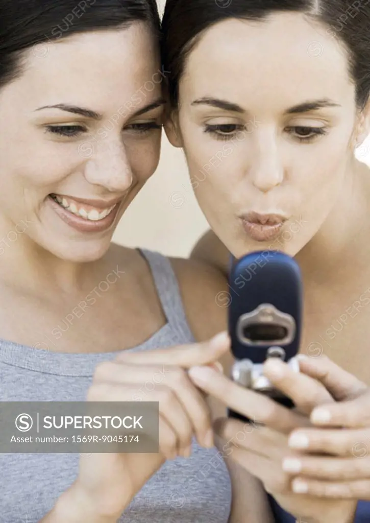 Two young women looking at cell phone together