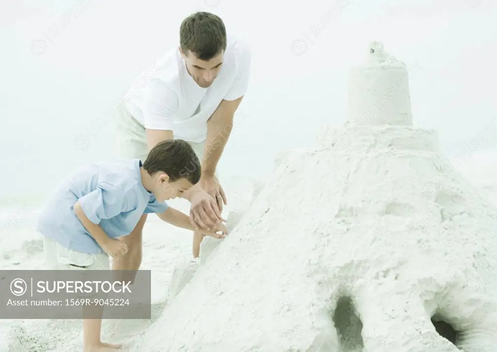 Father and son building sand castle at the beach
