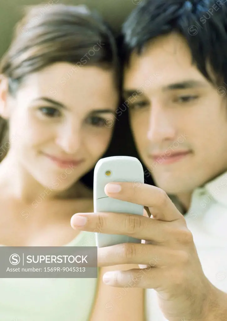 Young couple looking at messaging phone