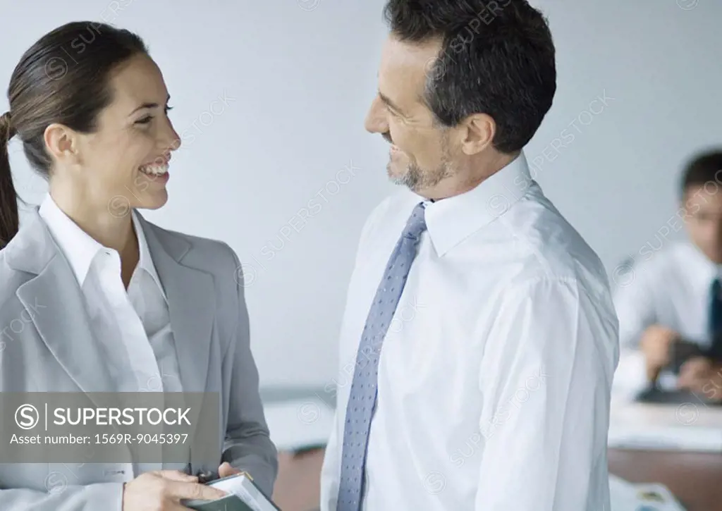 Two business colleagues smiling at each other