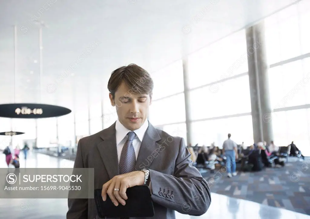 Businessman checking watch in airport