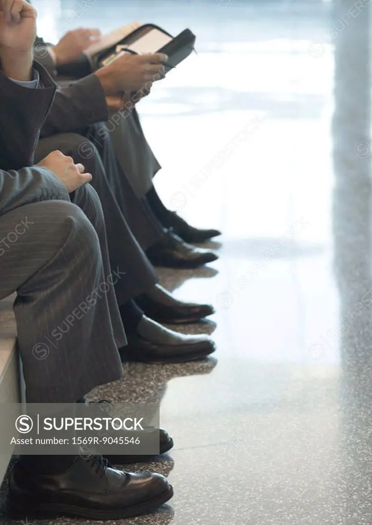 Low section of businessmen sitting in a row