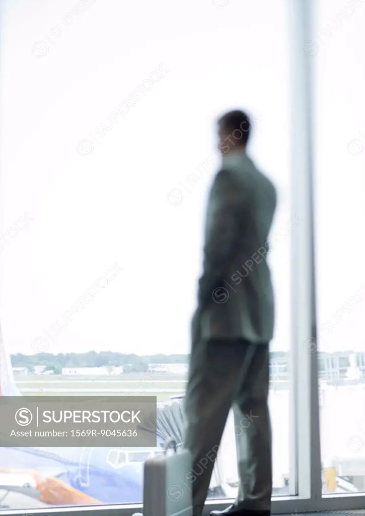 Man standing by window in airport
