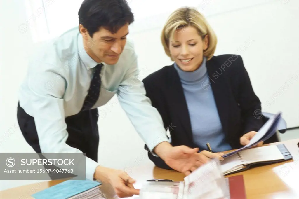 Business colleagues, man leaning over woman´s shoulder