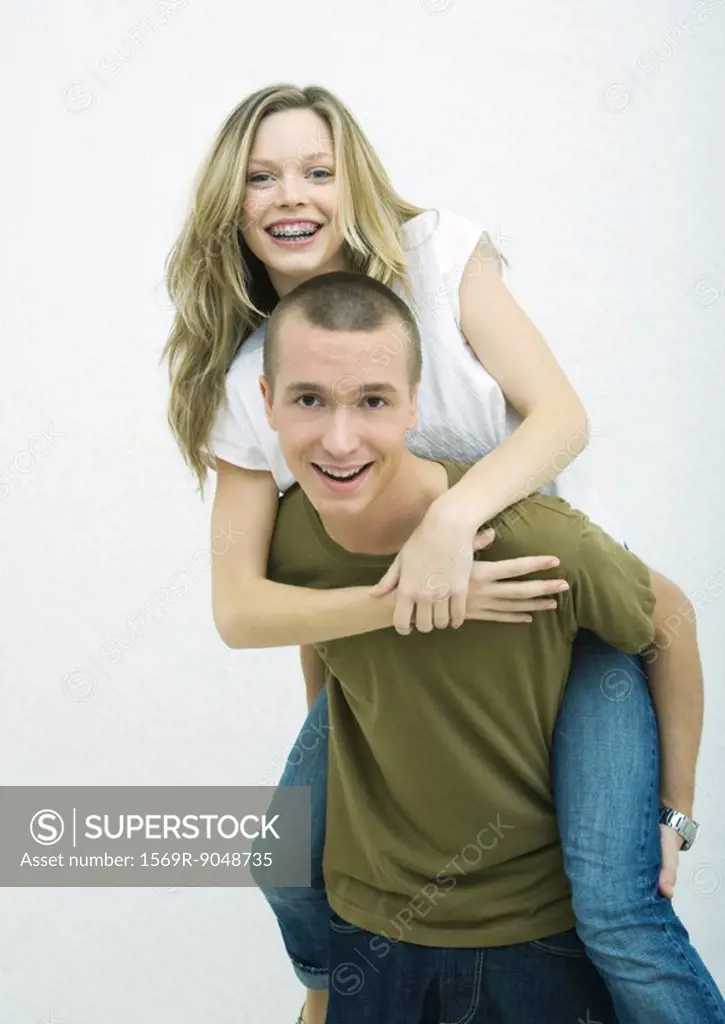 Young couple, teenage girl on young man´s back, white background