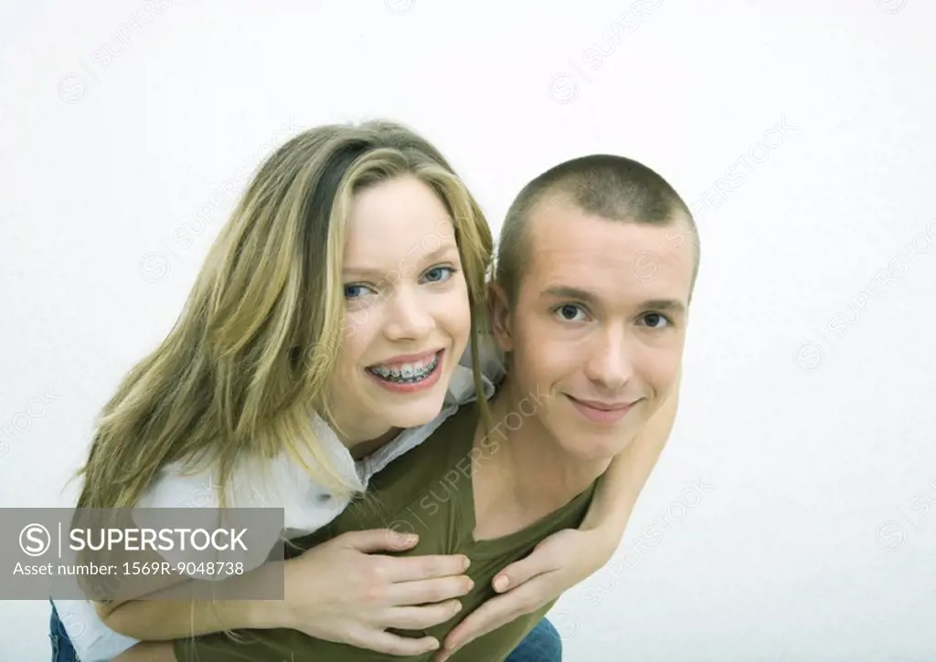 Young couple, teenage girl on young man´s back, white background
