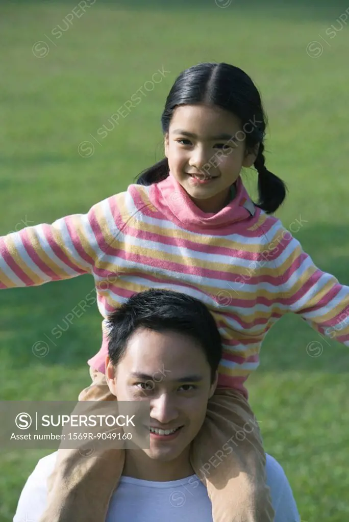 Girl sitting on father´s shoulders