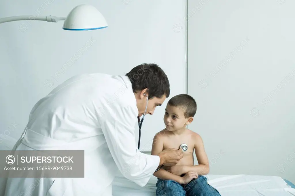 Doctor listening to boy´s chest with stethoscope