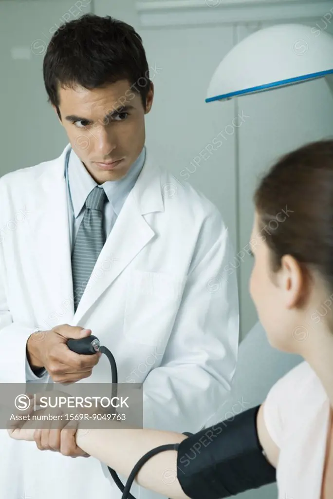 Doctor taking woman´s blood pressure