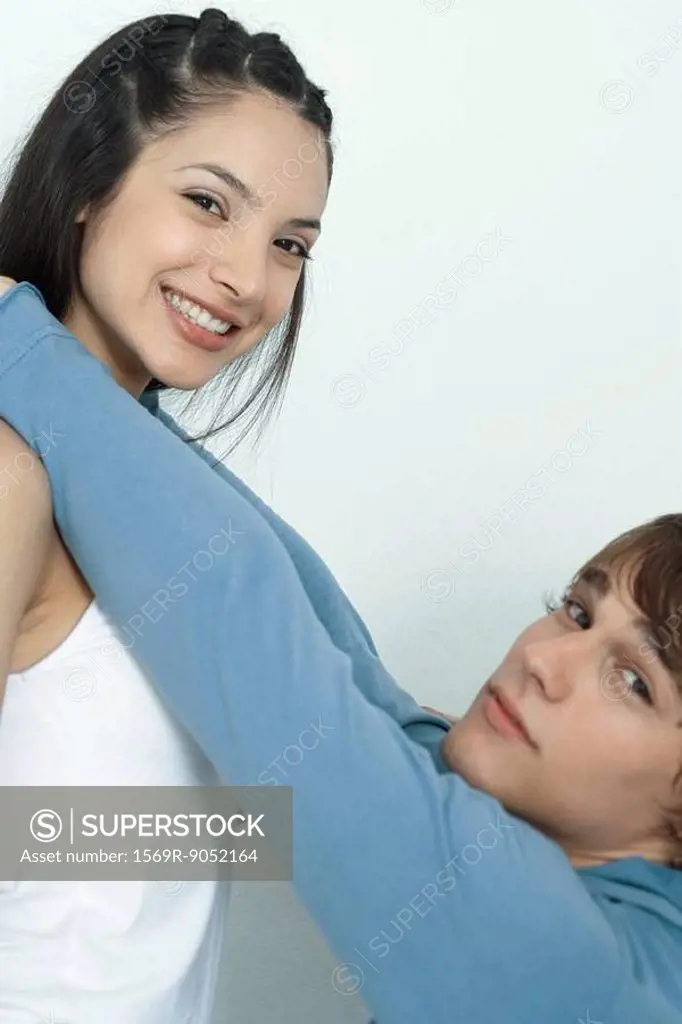Young couple, man reaching up to put arms around woman´s neck, portrait