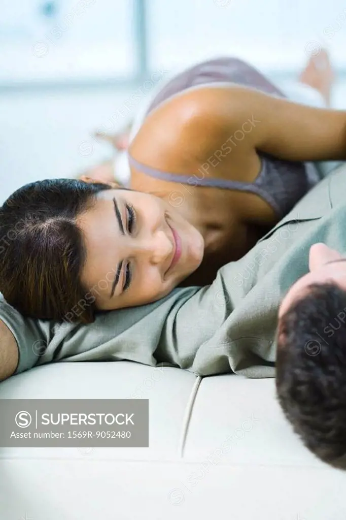 Young couple lying down in each other´s arms, smiling