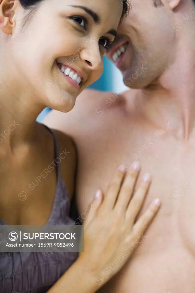 Couple nuzzling, woman´s hand on man´s bare chest, close-up