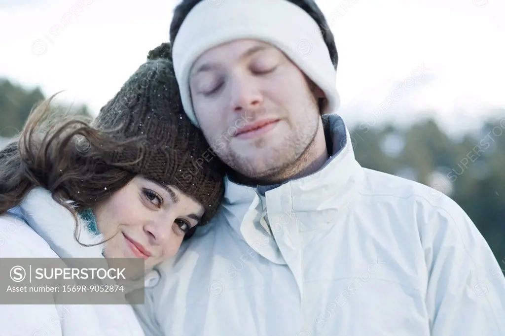 Young couple in ski clothes, young woman resting head on boyfriend´s shoulder