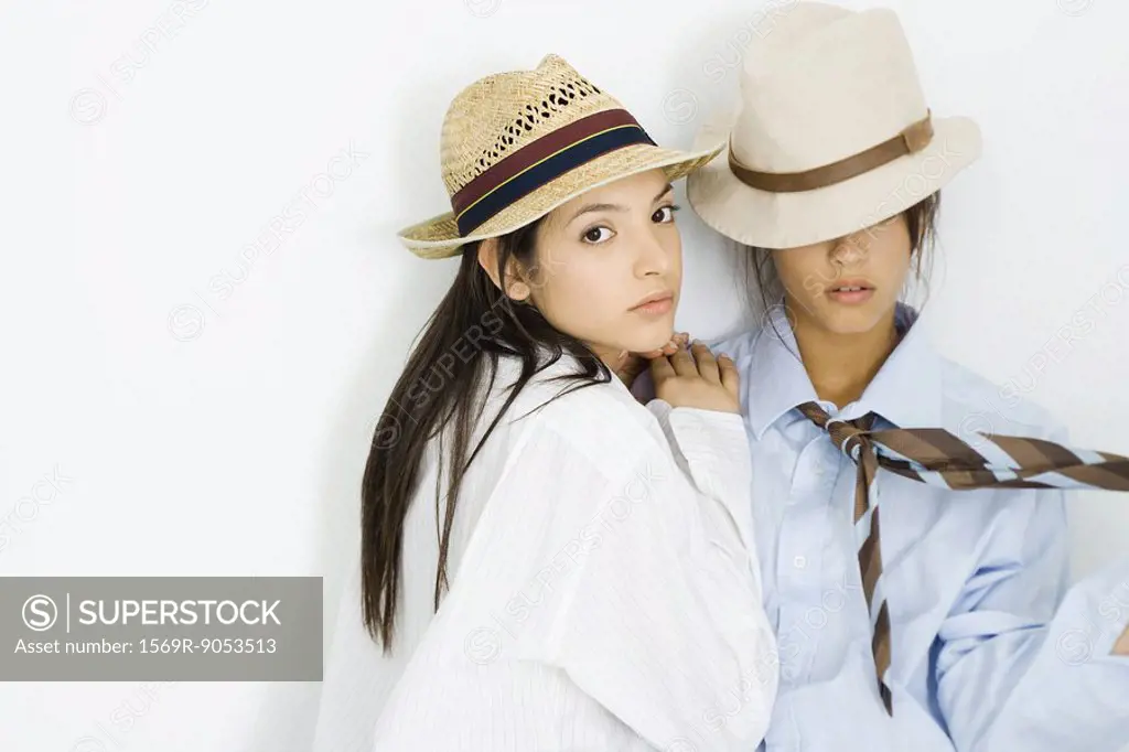 Two young females dressed in men´s clothing, one looking at camera