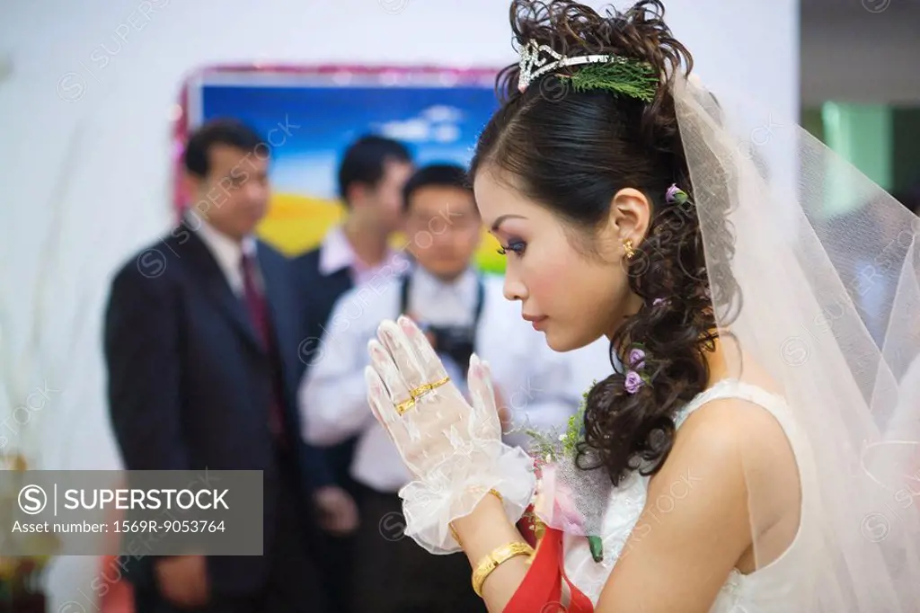 Chinese wedding, bride´s hands clasped in prayer, side view