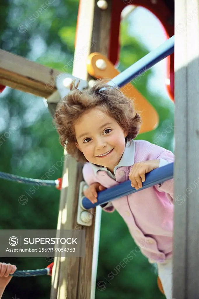Little girl playing on jungle gym, portrait
