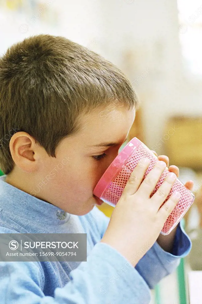 Child drinking from plastic cup, side view