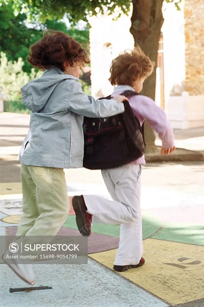 Little girls playing hopscotch together