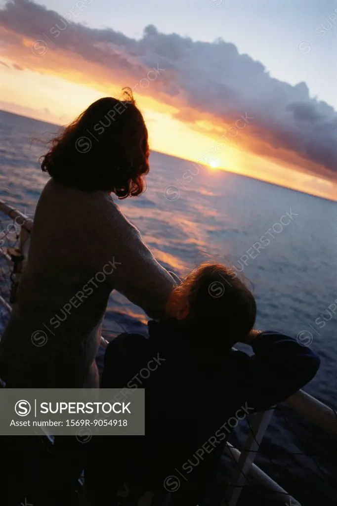 Mother and daughter on deck, looking at sunset