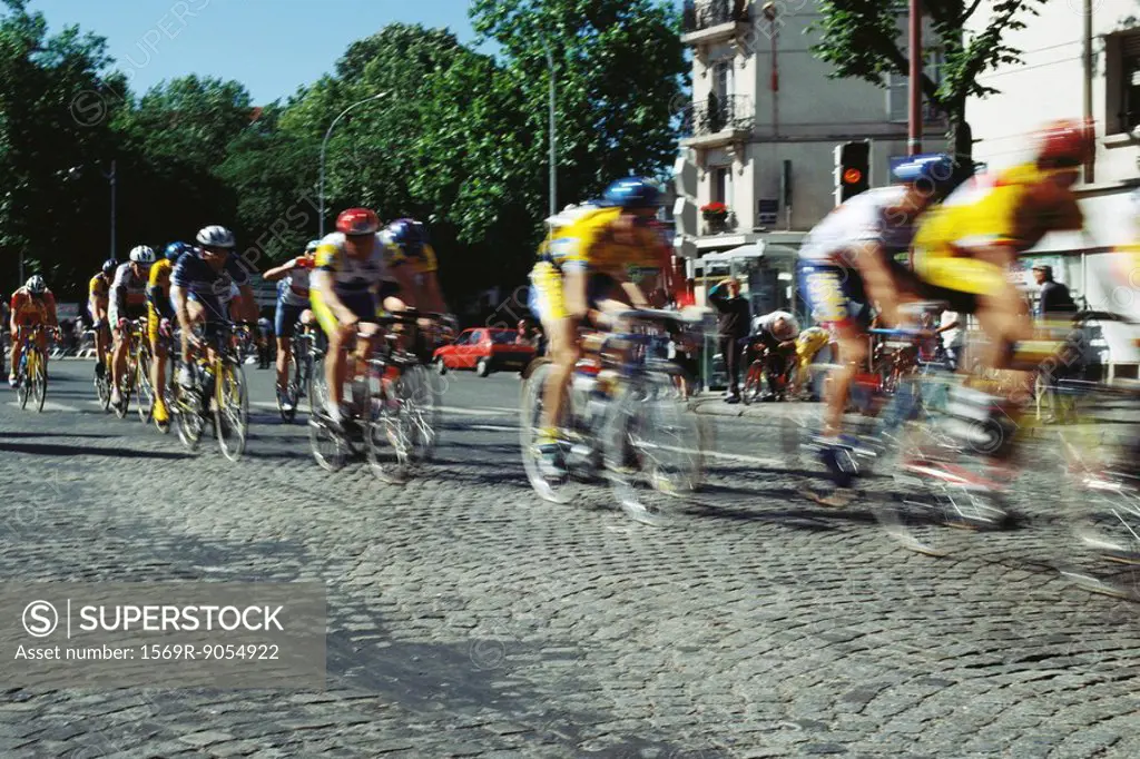 Cyclists racing on cobblestone street