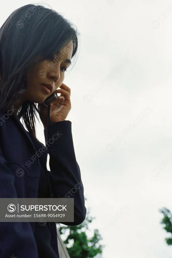 Woman using cell phone outdoors, low angle view