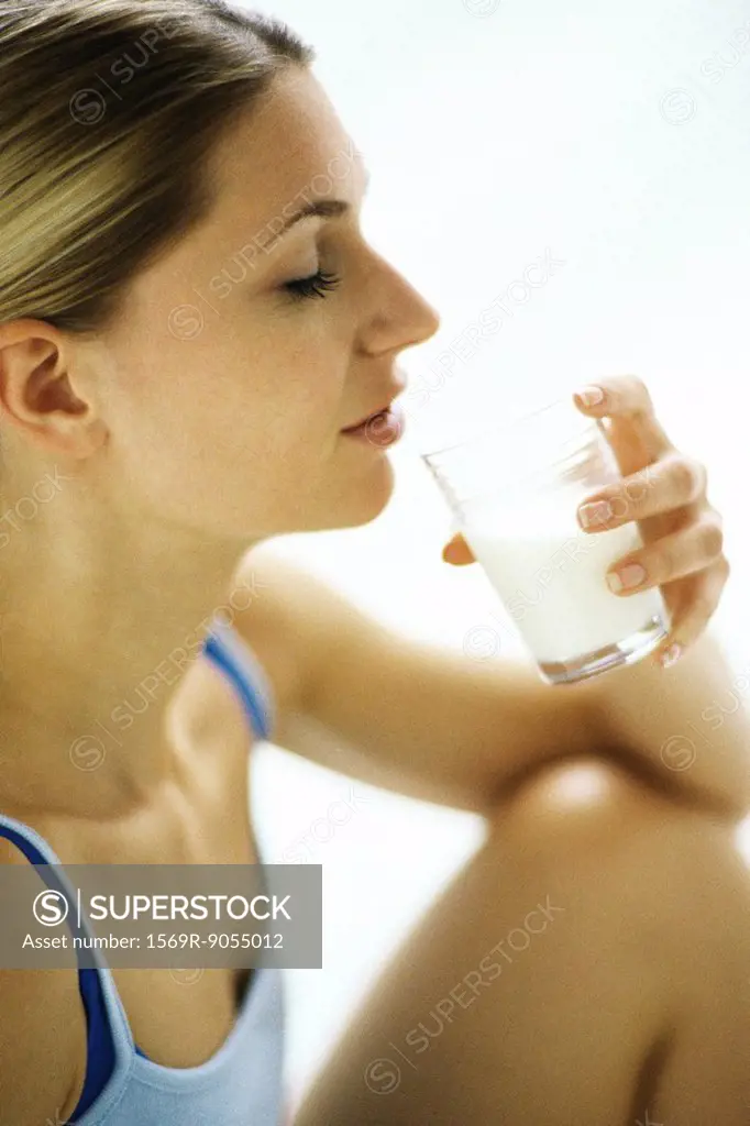 Woman drinking glass of milk, side view