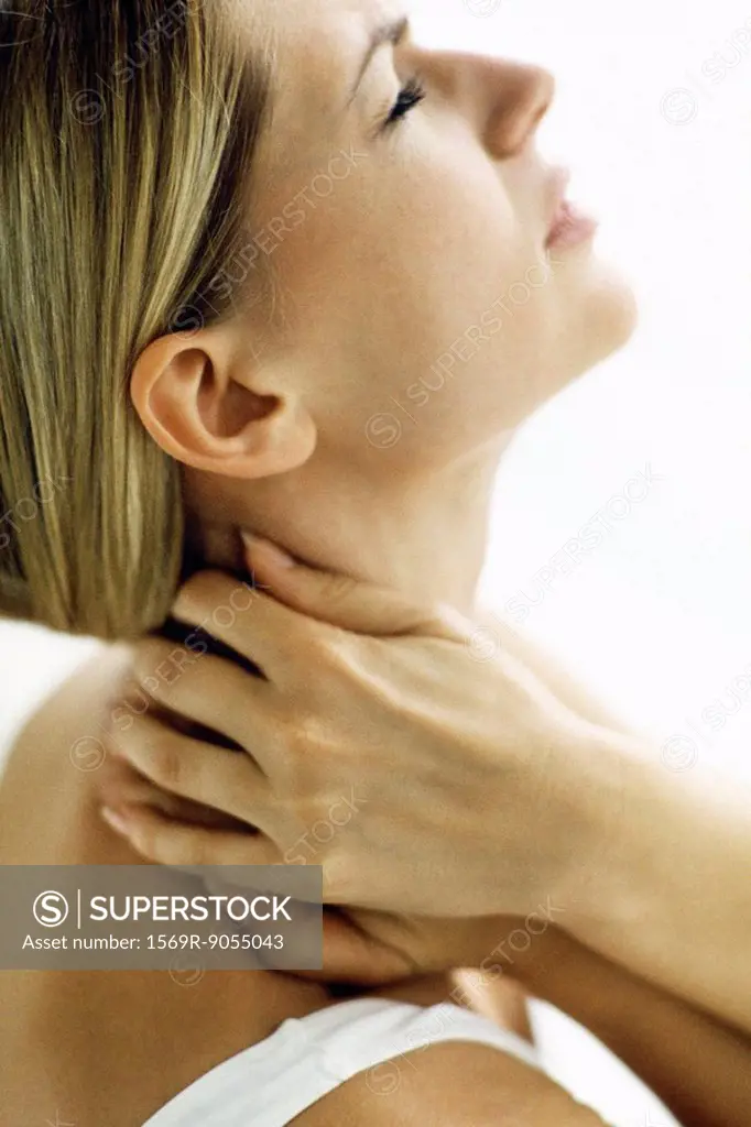 Woman holding neck with both hands, head back