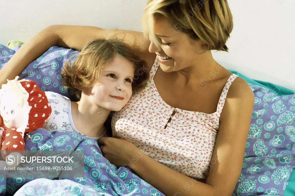 Mother and daughter lying in bed together