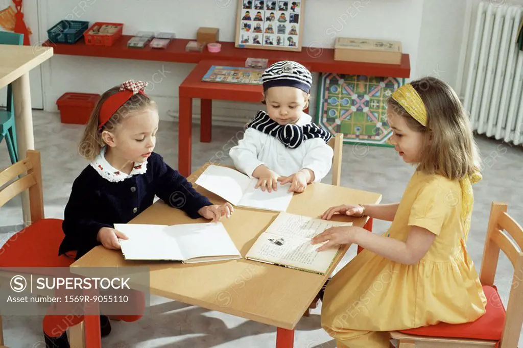 Children sitting around table with books