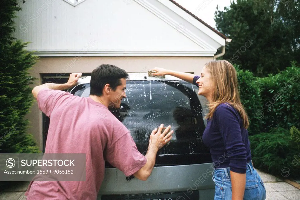 Couple washing car together