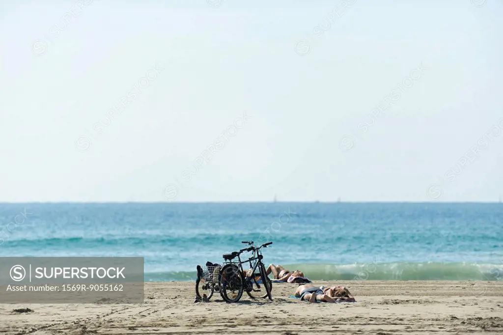 Sunbathers and bicycles on beach