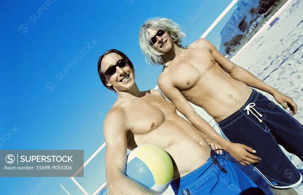 Friends at beach preparing to play beach volleyball