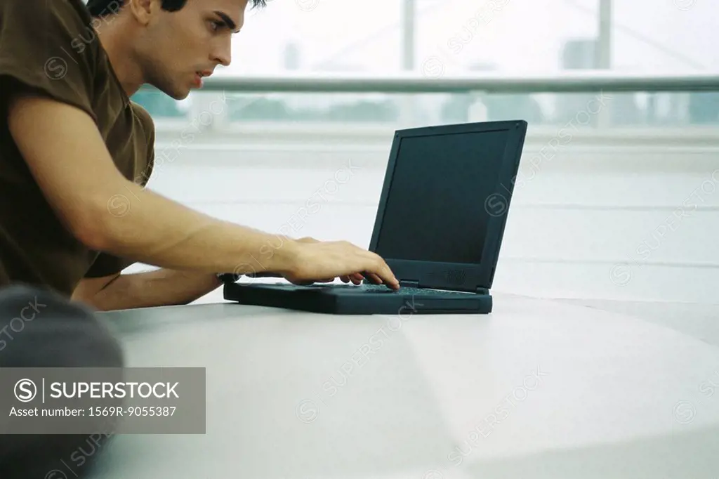 Man reclining on floor using laptop computer