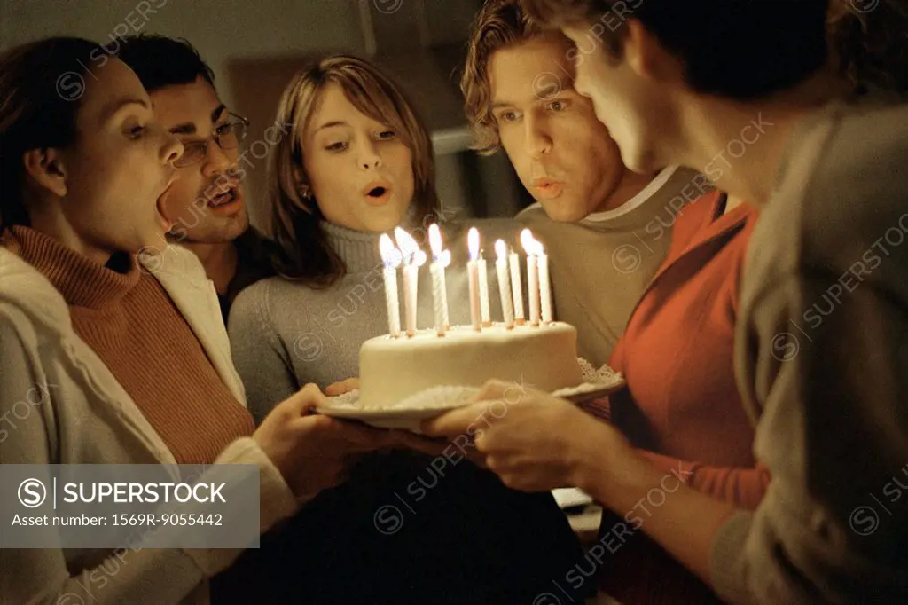 Friends blowing out birthday candles together