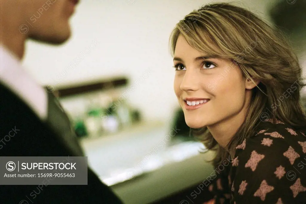 Young woman smiling looking up at man