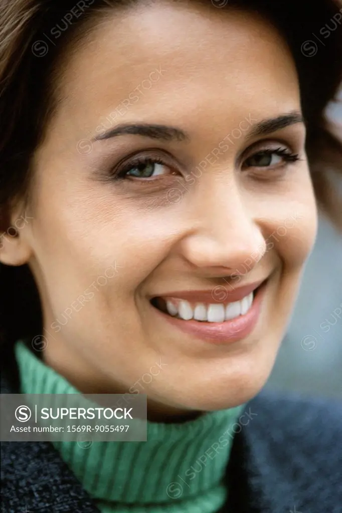 Woman smiling at camera with amusement, portrait
