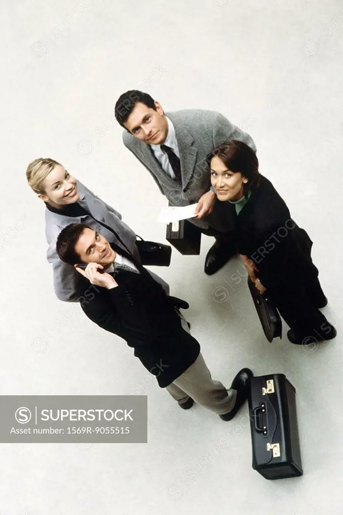 Business associates standing together looking up at camera, high angle view