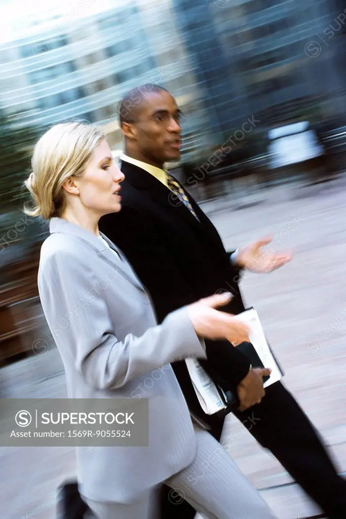 Businessman and businesswoman walking together in conversation