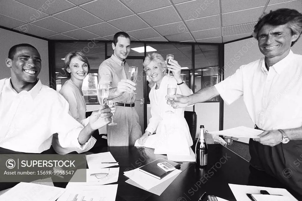 Business associates celebrating with champagne in office