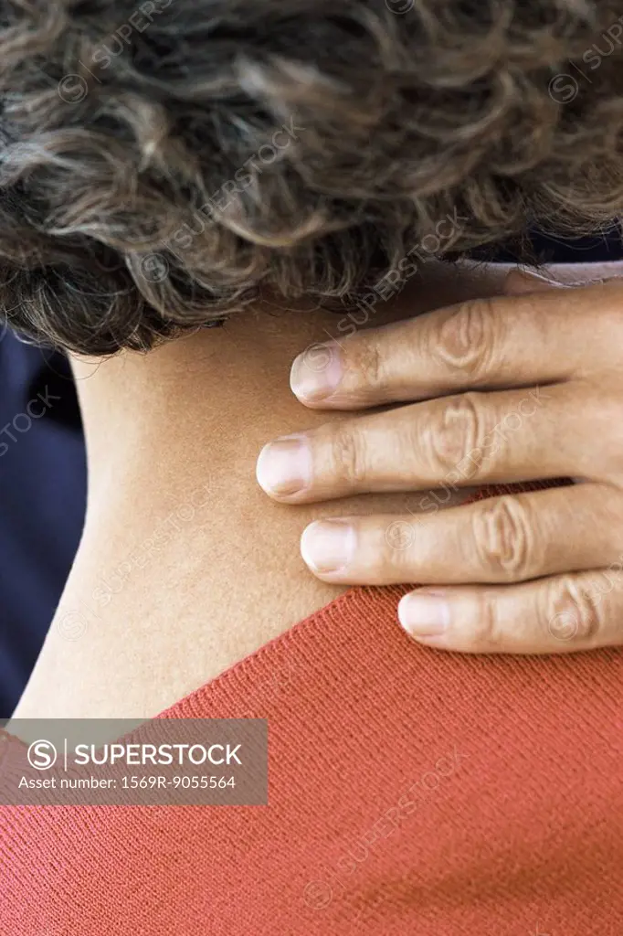 Man´s hand on back of woman´s neck, close_up