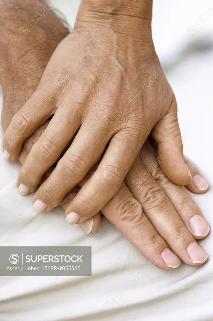 Woman´s hand resting on top of man´s hand, close_up