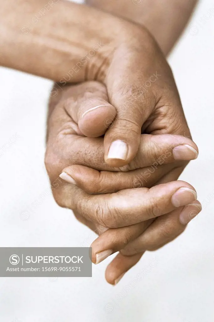 Couple holding hands, cropped view
