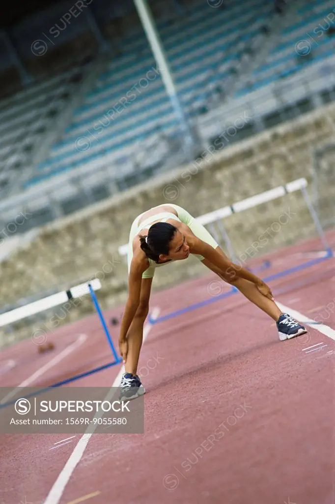 Woman doing stretches on running track