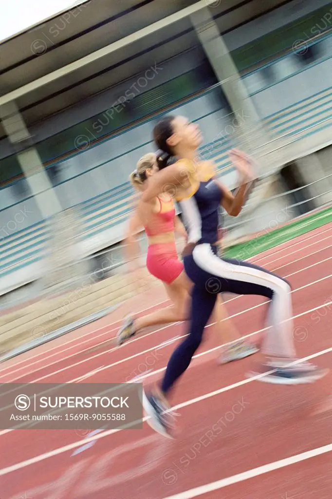 Women running on track, blurred